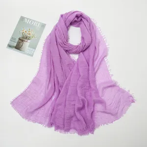 Detail shot of light purple crinkled cotton linen scarf with frayed edges texture showcase.