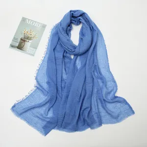 Blue cotton linen crinkled scarf with frayed edges, detailed view of soft texture and fringe.