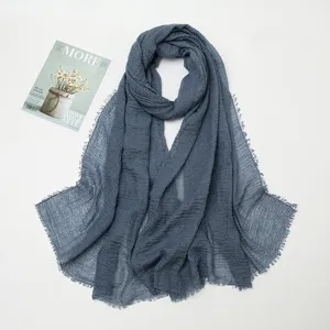 Grey blue cotton linen crinkled scarf detail flat lay, featuring frayed raw edges.