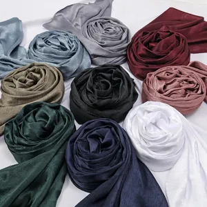 Detailed view of smooth crinkled satin hijab scarves in multiple vibrant colors for women.