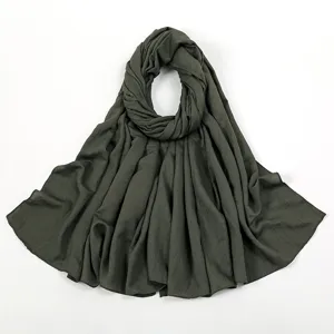 Detailansicht der dunkelgrünen, knittrigen Hijab Schal Textur, weiches Material Präsentation.
