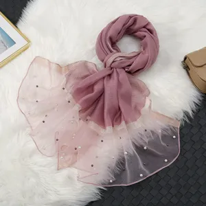 Close-up detail of pearl beaded organza scarf, elegant gradient pink sheer shawl for women.