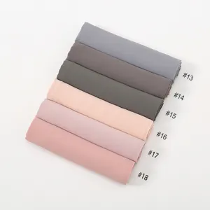 Detail view of solid color chiffon hijab scarf, showing neatly rolled fabric options.