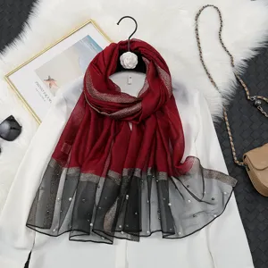 Detailed view of the elegant red and black gradient sheer scarf featuring delicate pearl embellishments.