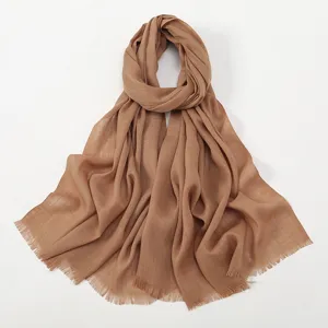Detail shot of the solid color slub cotton scarf showing fine texture and delicate fringe edge.
