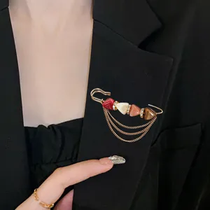 Exquisite safety pin brooch detail showcasing colorful beads and delicate hanging chains design.