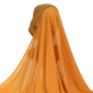 Detail view of solid color jersey hijab cap and long orange scarf set for women style.