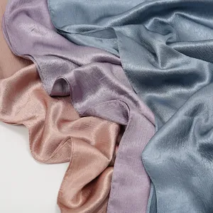 Close-up view of crinkled satin scarf fabric showing smooth texture and delicate pleats.