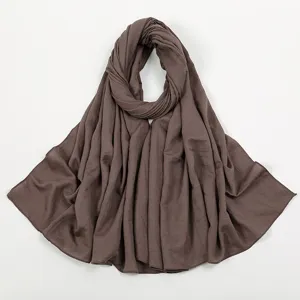 Detailansicht eines einfarbigen, knittrigen braunen Hijab-Schals mit feiner Textur.