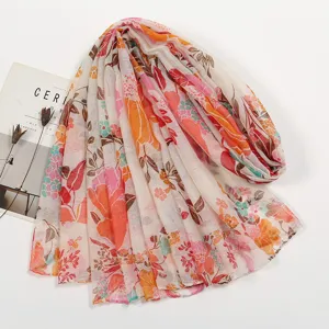 Vista dettagliata della lunga sciarpa in voile da donna con vivace stampa floreale e colori.