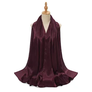 Detailed view of the dark red pleated satin hijab scarf, showing smooth drape and texture.