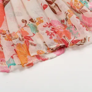 Vista dettagliata di una sciarpa leggera da donna con motivo floreale colorato in voile.