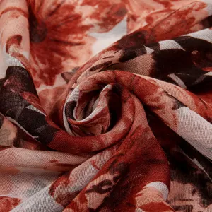 Sciarpa lunga da donna con stampa floreale in tessuto voile leggero dai toni rossi.