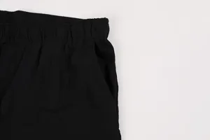 Close-up of black drawstring shorts detail, featuring comfortable elastic waistband and pocket.