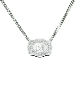 Silver-tone belt buckle pendant necklace with embossed letter M and curb chain detail.