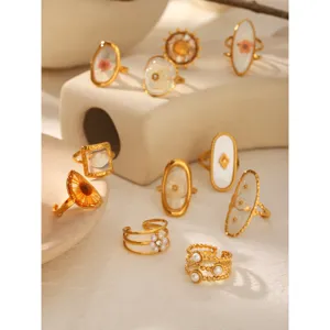 Group of gold stainless steel open rings with dried flowers and elegant pearls.