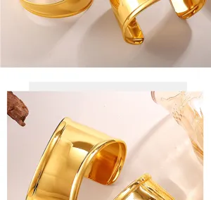 Primer plano de un brazalete ancho dorado irregular minimalista con acabado brillante
