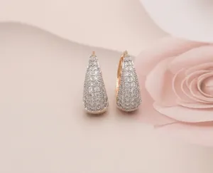 Nahaufnahme eleganter goldener U-förmiger Ohrringe mit funkelnden Zirkoniasteinen.