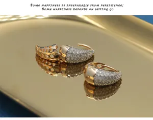 Detailansicht goldener U-Ohrringe mit Zirkonia-Besatz und modischem Hohlmuster.
