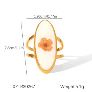 Detailed view of an oval stainless steel ring featuring a dried flower and size dimensions