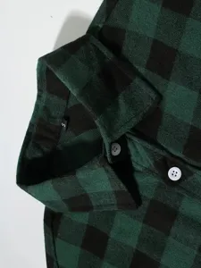 Close-up detail of the men's green and black plaid flannel shirt collar and white button.