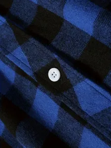 Blue and black plaid flannel shirt fabric detail closeup showing soft texture and white button.