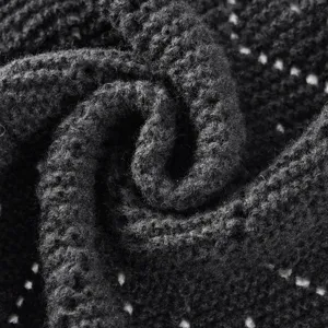 Détail châle tricoté noir texture macro, vue rapprochée tissu maille douce affichage.