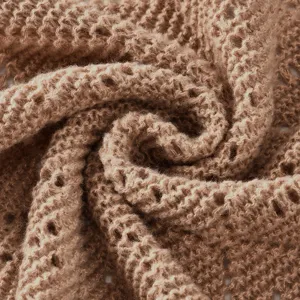 Gros plan détaillé d'un tissu de châle en tricot doux, mettant en valeur la texture en maille.
