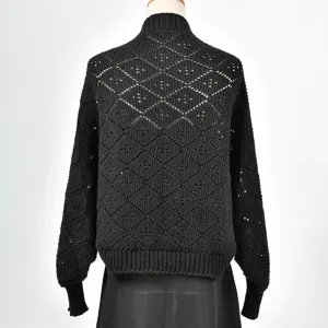 Détail de gilet en tricot noir avec motif ajouré en losanges au dos et style court.