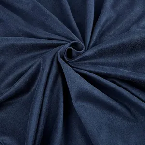 Dark blue suede fabric detail closeup showing soft velvet texture and natural folds.