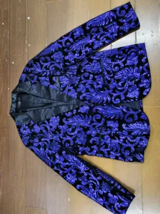 Détail de blazer à sequins bleus pour hommes avec motif floral étincelant et revers noir.