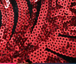Gros plan détaillé du magnifique tissu à motif de sequins rouges pour costume de scène.