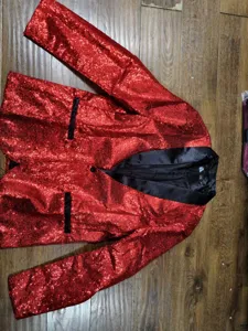 Close-up of red sequin men blazer with black lapel, dazzling performance party jacket.