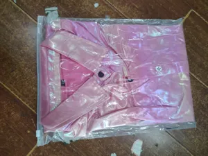 Chemise brillante rose style disco pour homme pliée vue de détail pour fêtes.