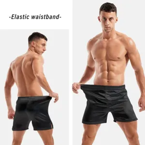 Detail view of men's silky satin boxer shorts in solid black with elastic waistband.