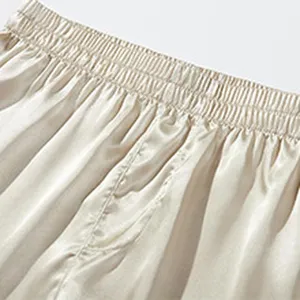 Close-up view of men's satin boxer shorts elastic waistband and smooth fabric detail.