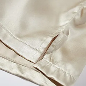 Detail shot of men's satin boxer shorts showing side slit and fine stitching texture.