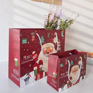 Sac cadeau en papier de Noël rouge avec motif de Père Noël mignon, emballage festif de fête.