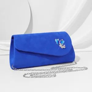 Blue velvet evening clutch bag with silver chain strap and sparkling butterfly detail.