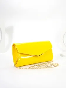 Bright yellow patent leather envelope bag detail showcasing the elegant gold chain strap.