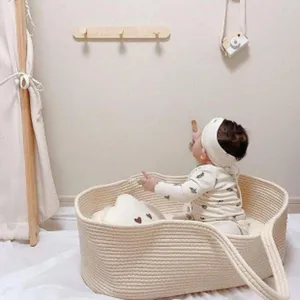 Détail d'un panier de rangement en coton pour bébé avec un enfant à l'intérieur