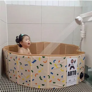 Baignoire bébé pliable portable avec motif géométrique coloré dans une salle de bain