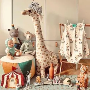 Scène de nurserie chaleureuse avec une peluche girafe géante et des habits de bébé