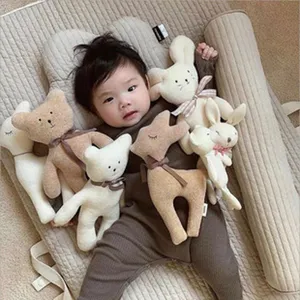 Scène de vie montrant un nourrisson asiatique sur un tapis de jeu matelassé avec des peluches