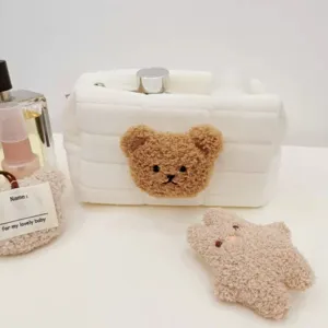 Gros plan du patch ours mignon sur un sac de rangement en peluche matelassé blanc
