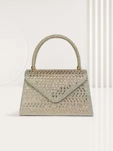 Detailed view of sparkly rhinestone evening handbag with metallic handle and flap design.