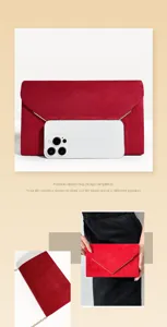 Red suede envelope clutch detail showing textured fabric, metallic V-clasp and chain.
