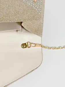 Gold glitter evening clutch bag interior detail, metal chain strap and clasp design.
