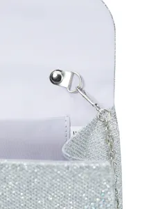 Close-up detail of silver glitter evening bag interior, metal clasp and chain strap.