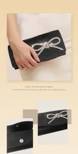 Detailed view of black pleated evening clutch bag with sparkling rhinestone bow and magnetic snap.